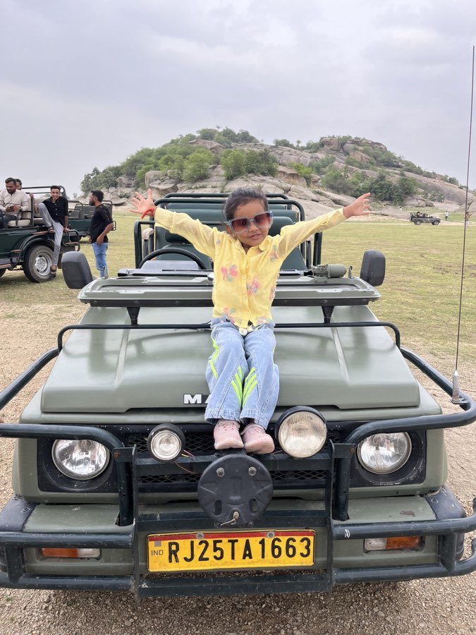 A young guest on the bonnet of a safari jeep in the Jawai hills