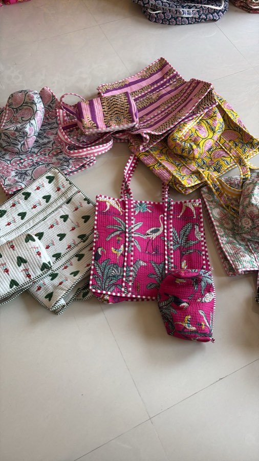 Hand-block-printed bags and purses laid out at a stall