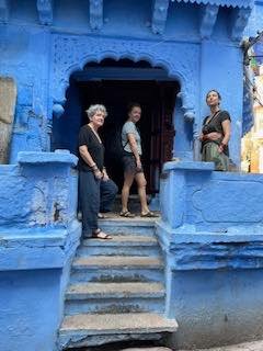 Three guests in a carved blue doorway